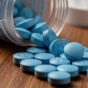 Close-up of Viagra pills spilling from an overturned bottle.