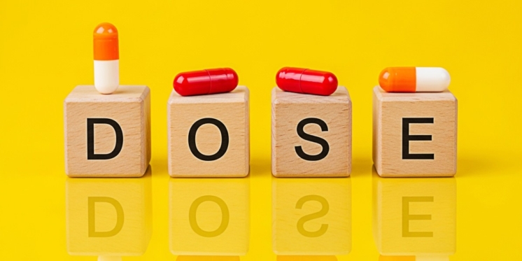 Red color pills on wooden blocks spelling 