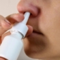 Close up of woman using nasal spray