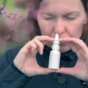 Woman using nasal spray outdoors