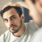 man checking hair in mirror
