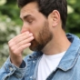 man struggling with hay fever outdoors