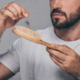 man pulling hair out of brush