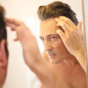 man checking receding hairline