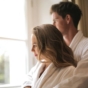 couple cuddling in front of window