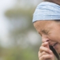 woman outdoors sneezing