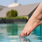 woman dipping toes into pool