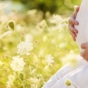 pregnant woman kneeling in wildflower field