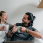happy couple sat with hot drinks