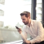 man in white shirt using phone