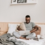 man using laptop in bed