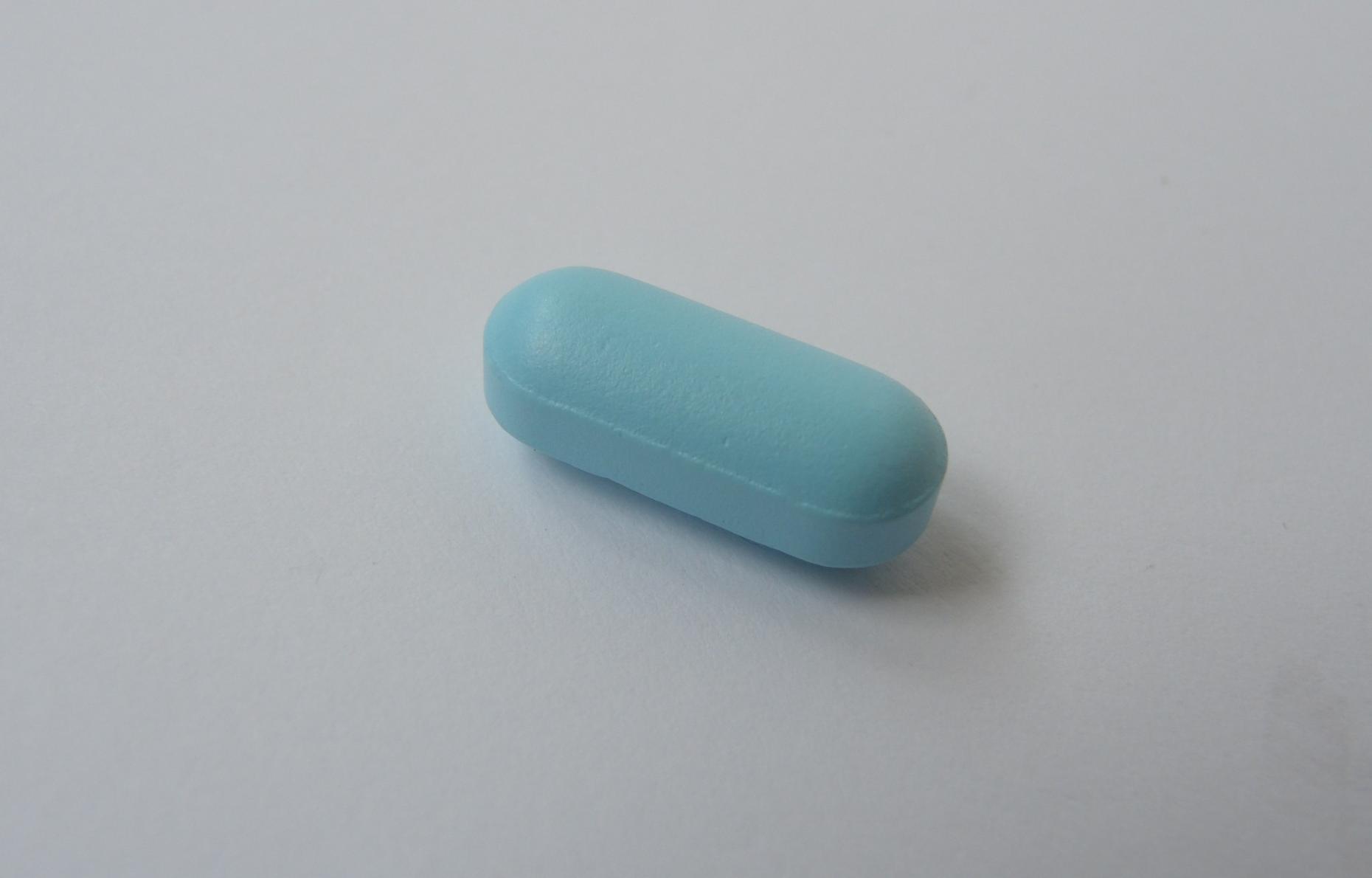 A loose Viagra 100mg pill on a white surface