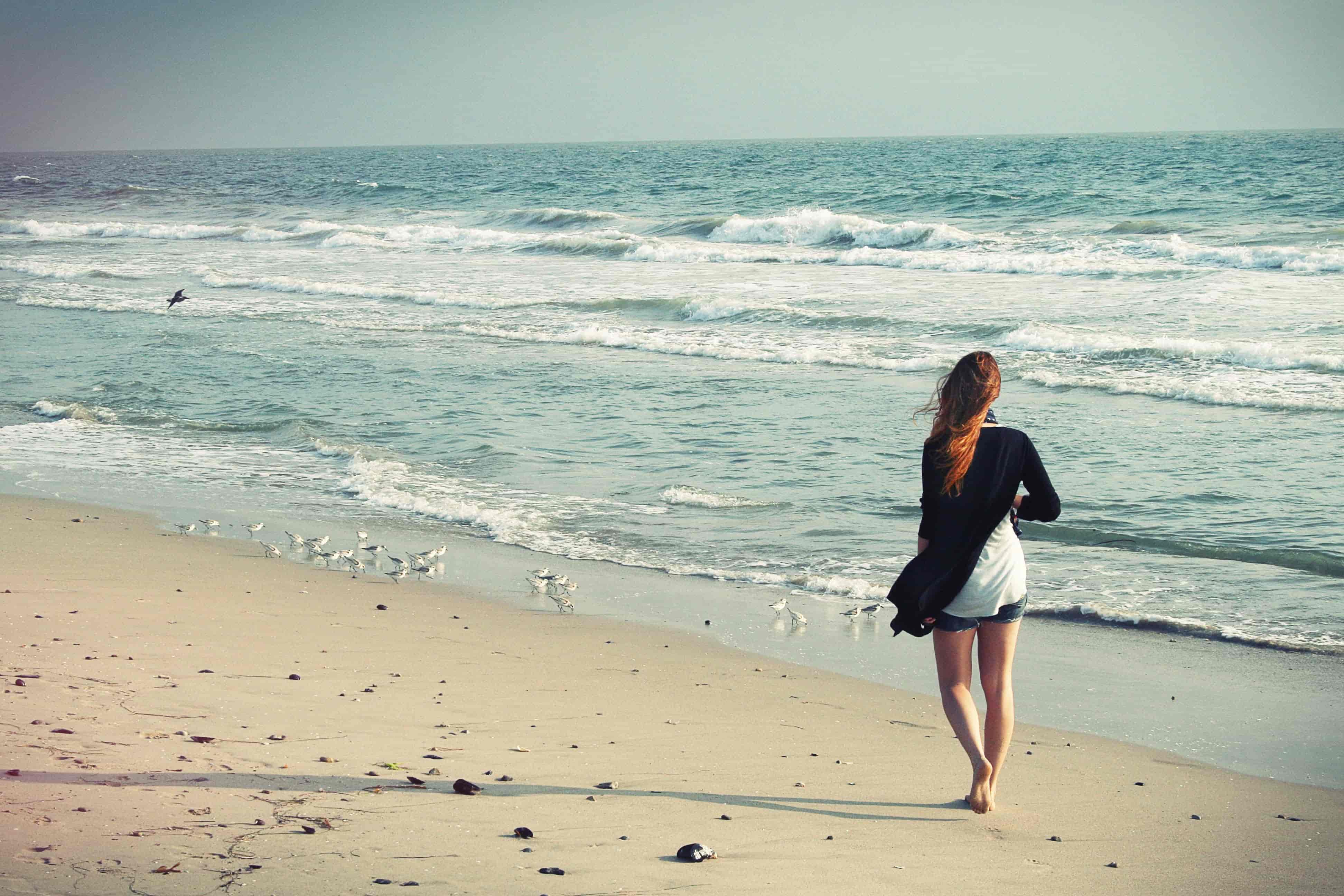 A woman walking along a beach