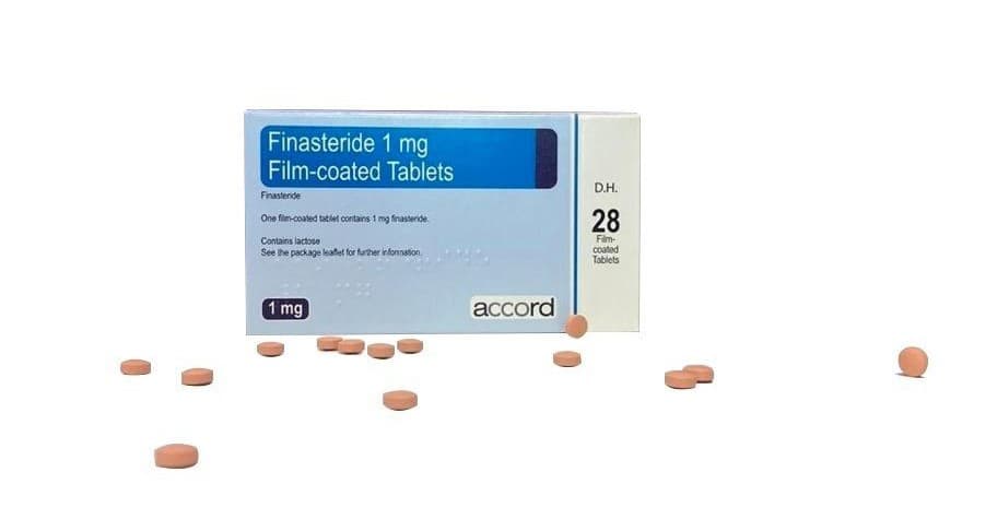 Box of accord branded finasteride (28 tablets) with few loose tablets scattered in front of it