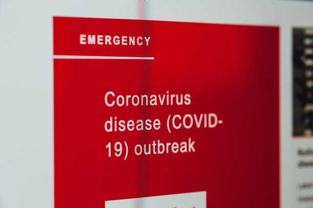 A red sign which states "Coronavirus disease (COVID-19) outbreak"