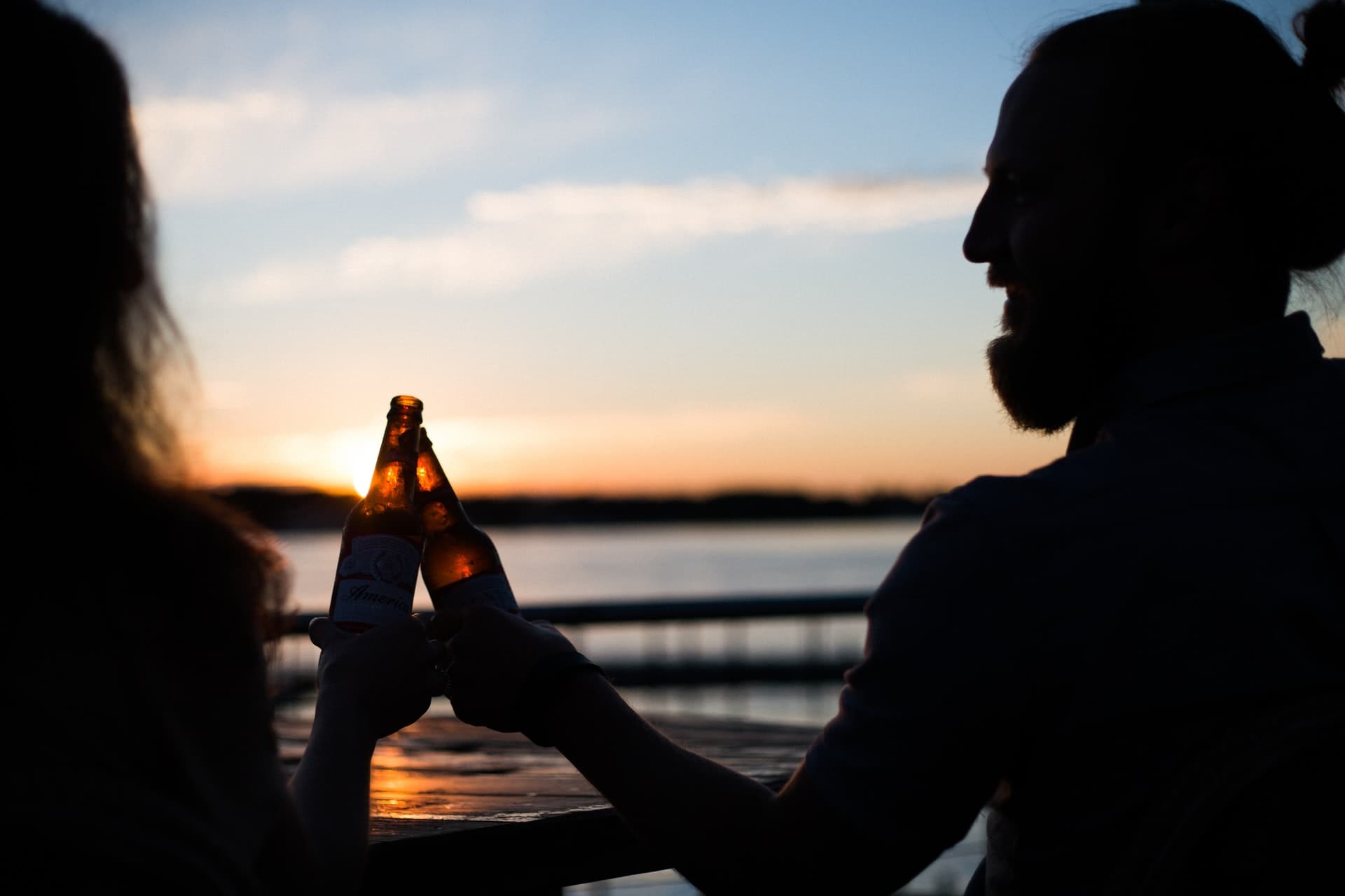 A man and woman having a glass of beer in the sunset