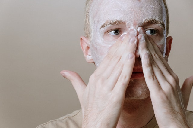 A man putting cream on his face