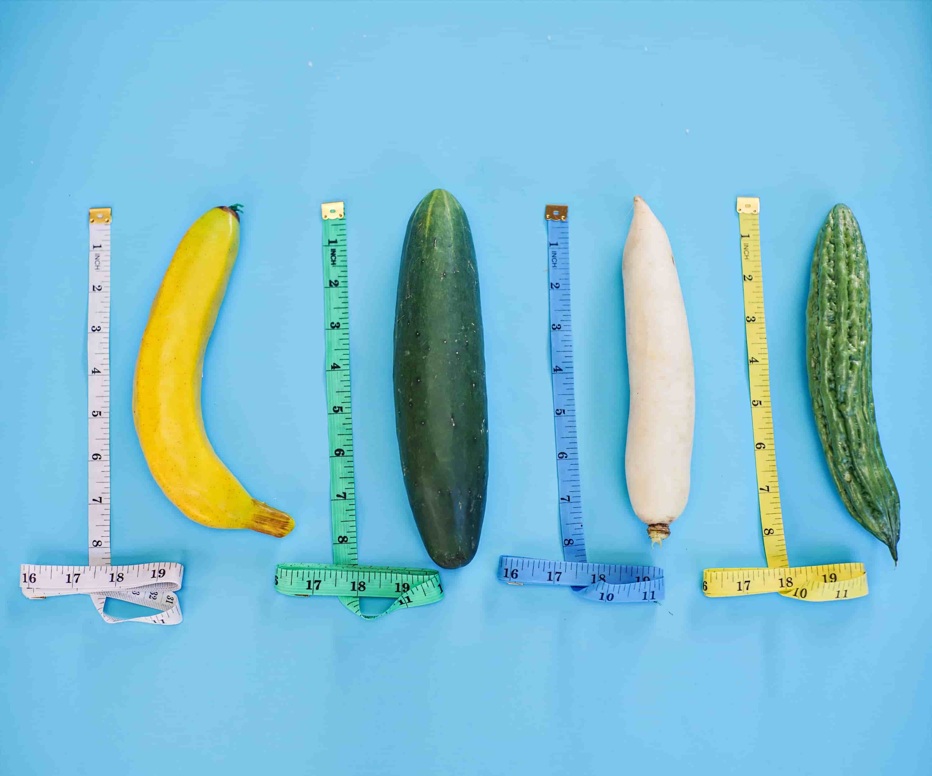 A collection of vegetables next to measuring equipment on a blue background