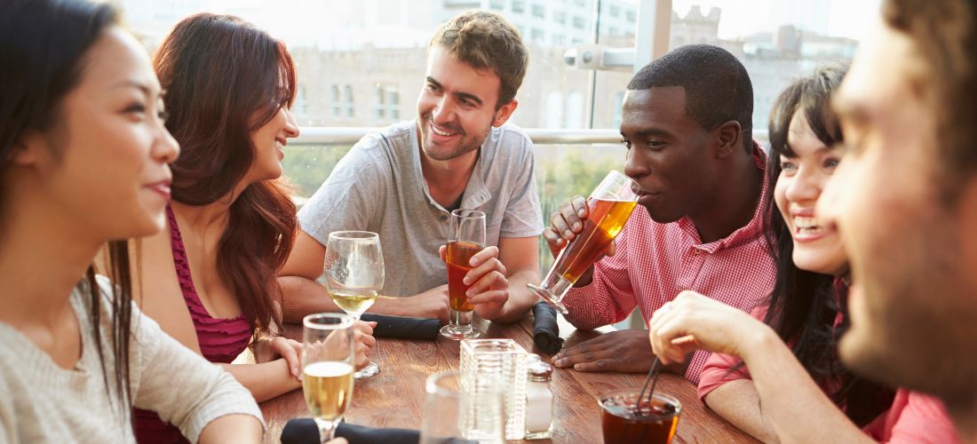 Friends drinking outdoors on a rooftop bar