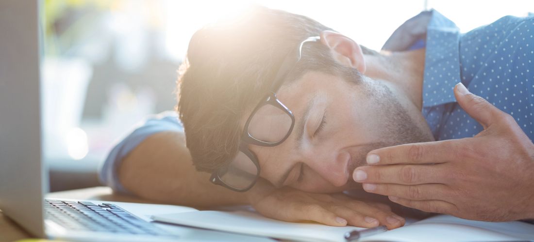 Man resting and yawning on his desk