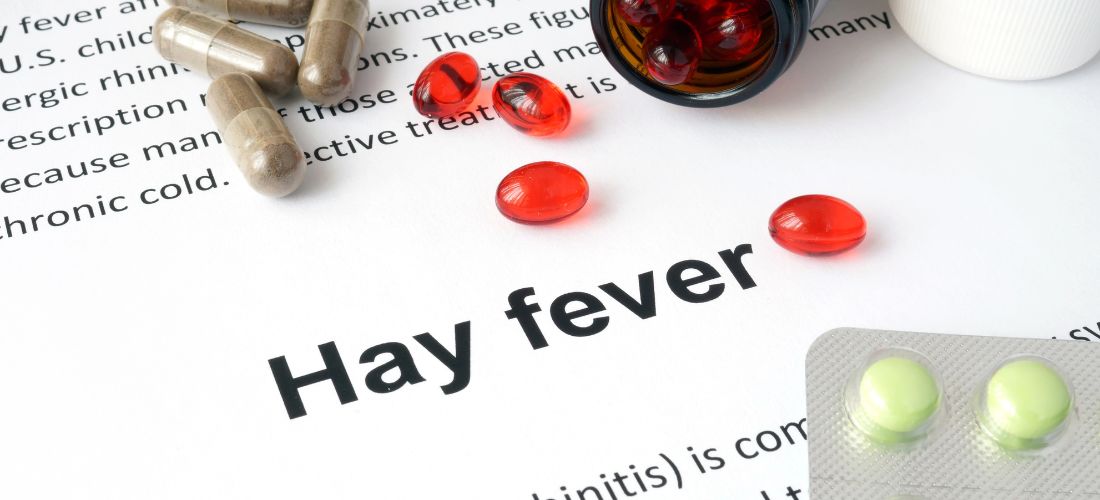 The word hay fever surrounded by pills