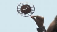 A man holding a tadalafil tablet looking at the clock