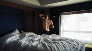 Man standing at edge of his bed