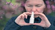 Man using nasal spray at home