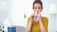 Woman using nasal spray and looking at the camera